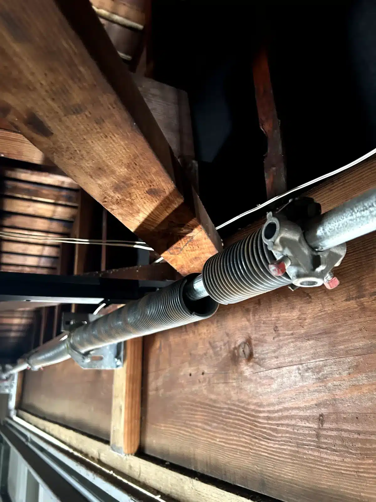 An up-close, interior view reveals a completely broken torsion spring split along the shaft, demonstrating a critical failure that requires professional garage door services in Richmond, CA.